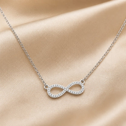 Collana in oro bianco con pendente a forma di infinito e zirconia.